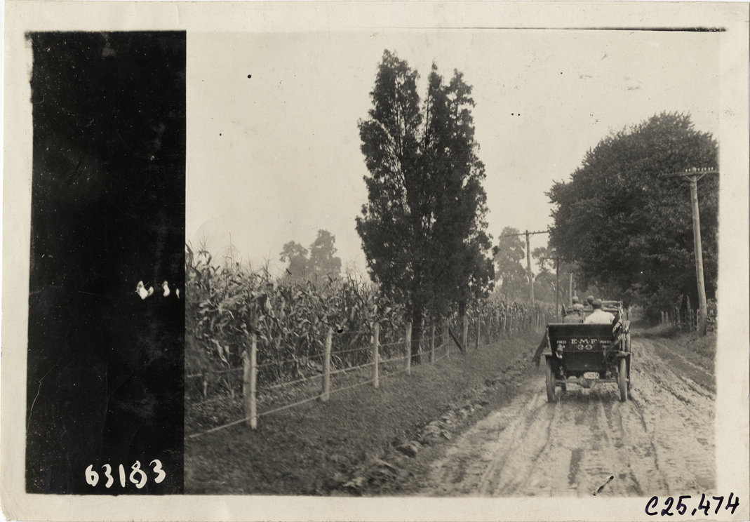 E-M-F press automobile traveling on rural road, 1910 Munsey Historic Tour