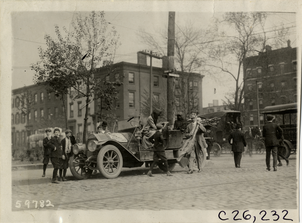 Motorists with automobile on street corner, 1910 New Jersey Reliability Run