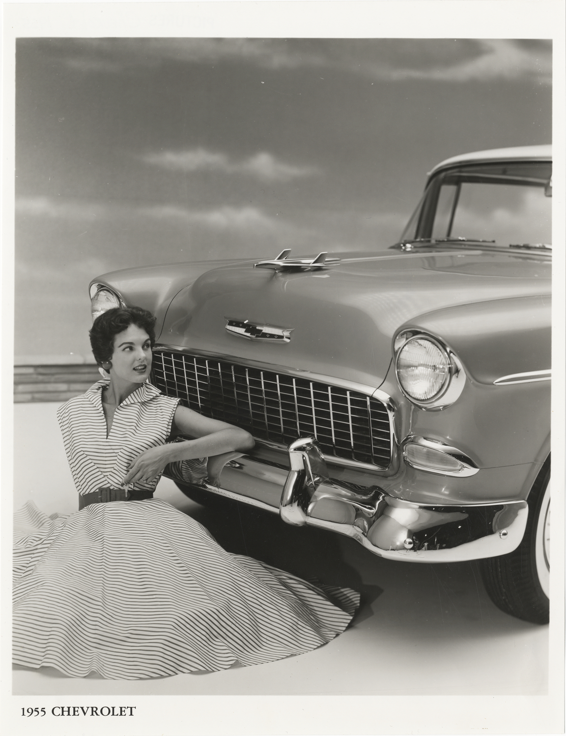 Model posing with 1955 Chevrolet automobile