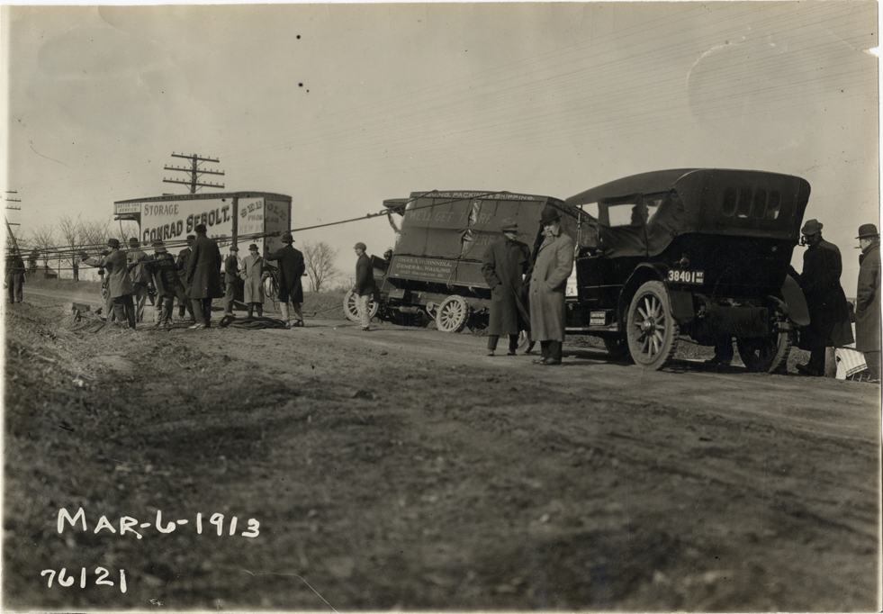 Truck being towed on rural road, 1913 Overman tires 10,000 mile demonstration
