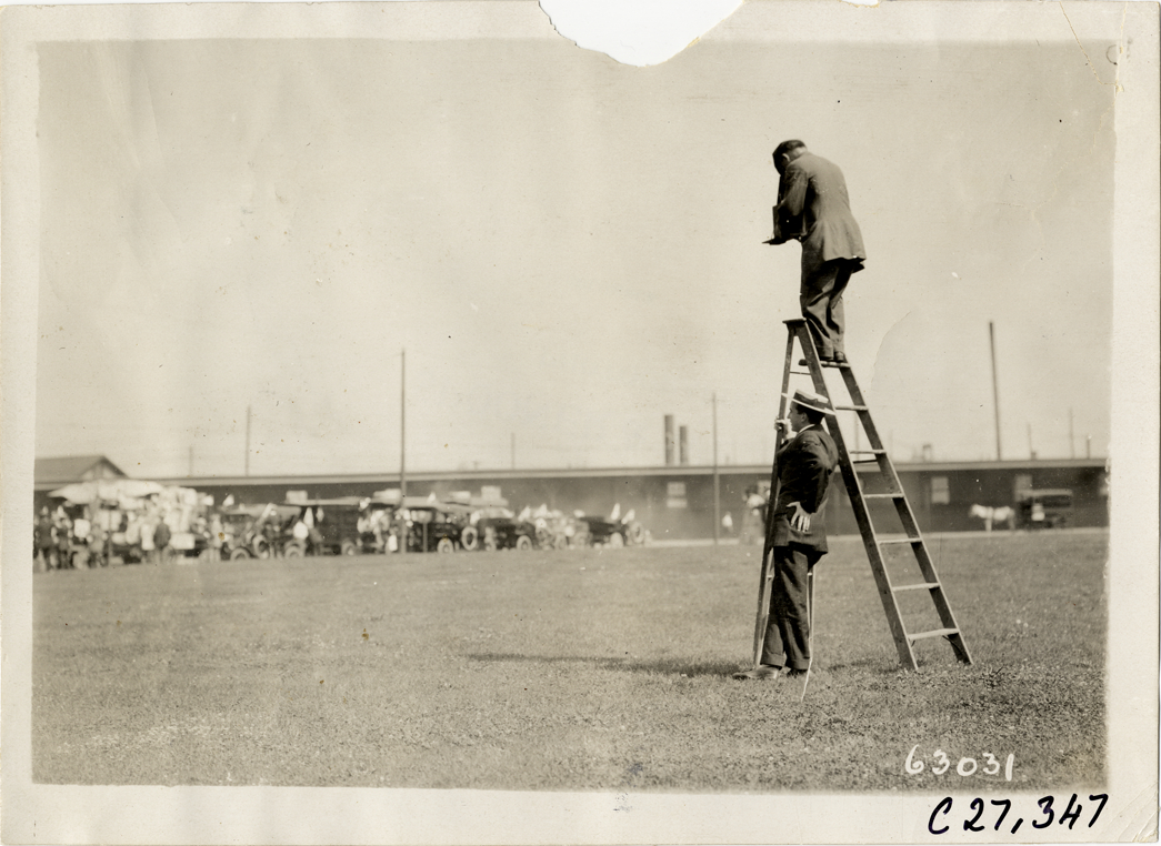 Photographer standing on ladder, 1910 North American Run