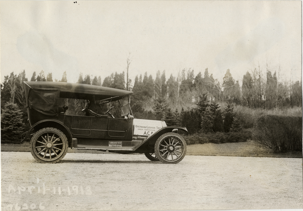 National automobile parked on driveway, 1913 Overman tires 10,000 mile demonstration