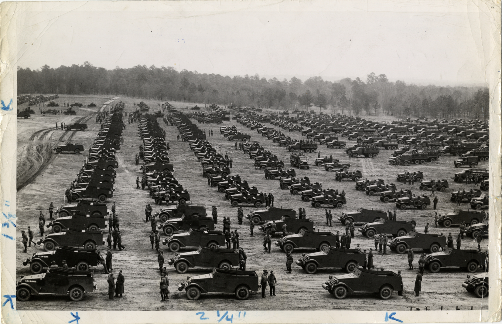 Soldiers standing with military trucks in field