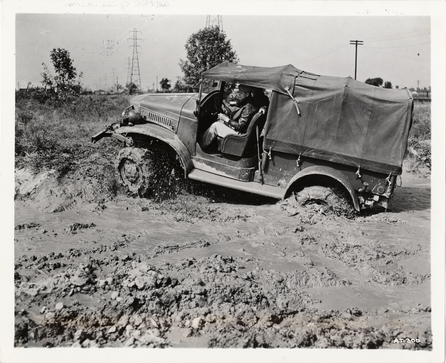 Soldier testing Dodge military truck in mud wallow