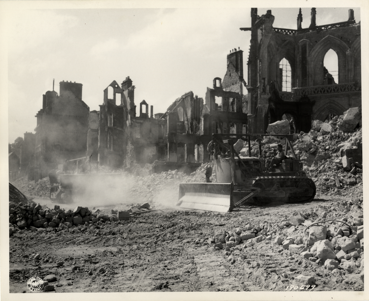 Bulldozers clearing debris from streets of Valognes, France