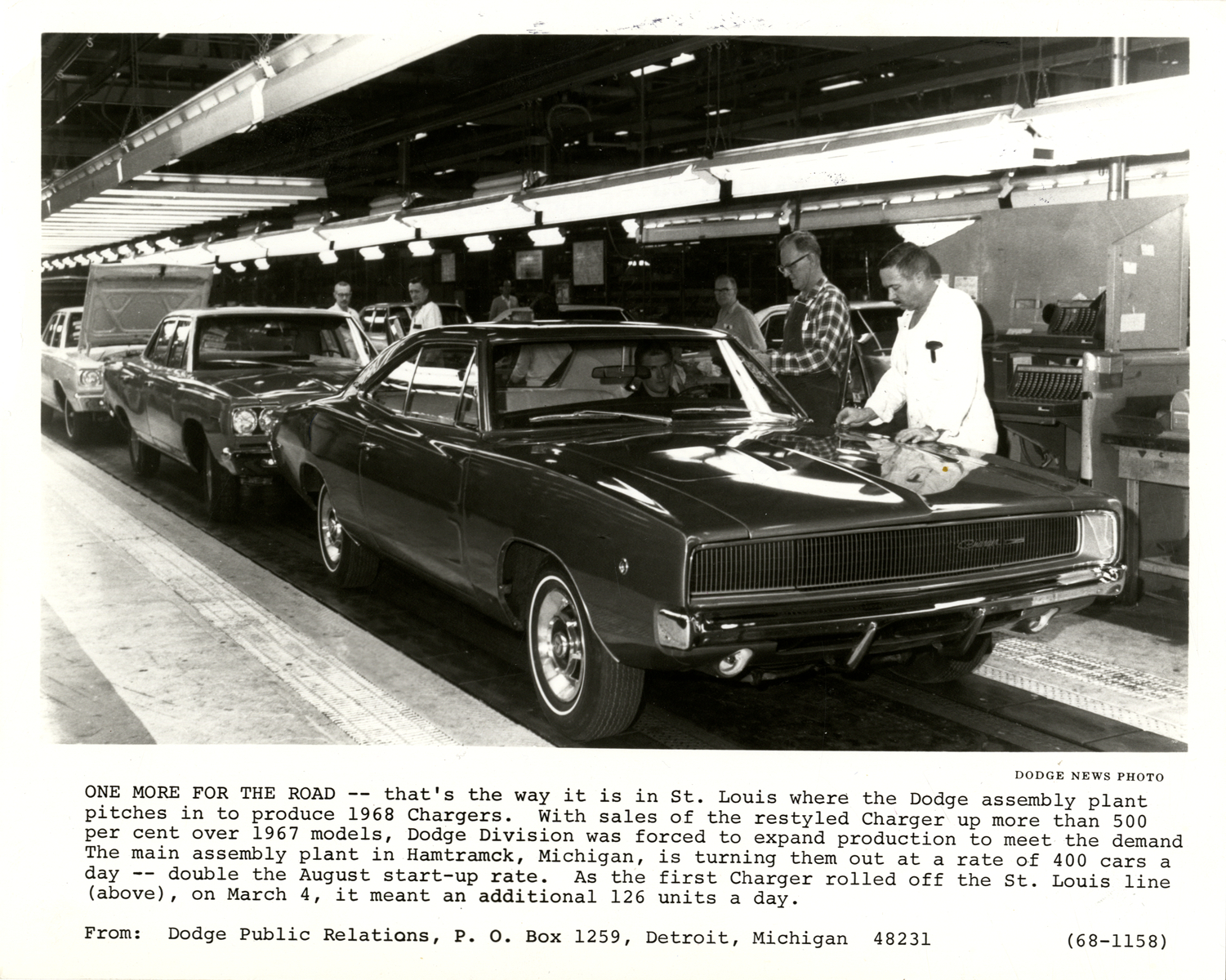 Workers with 1968 Dodge Charger automobiles on assembly line