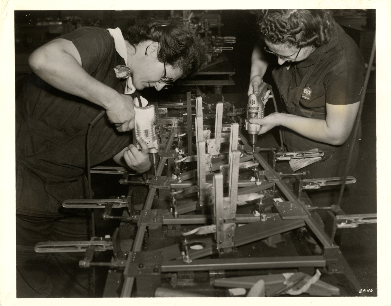 Women workers drilling cap strips for airplane wing
