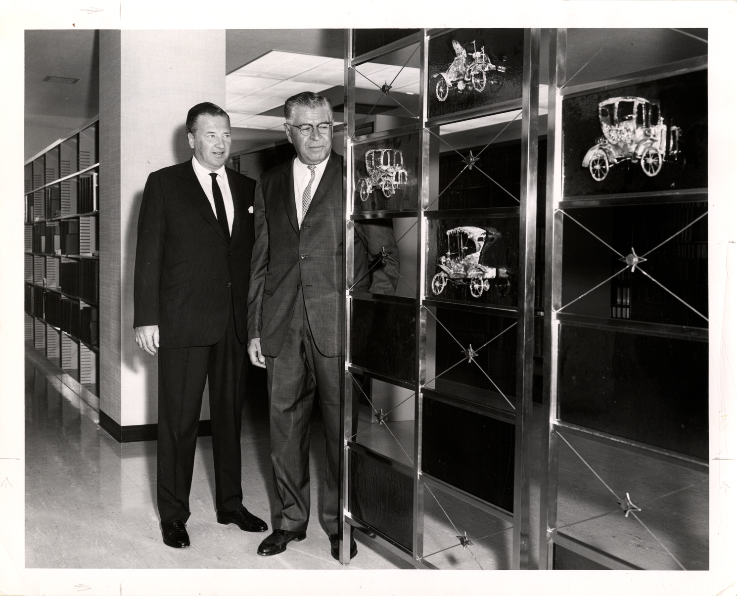 Henry Ford II and Ralph Ulveling posing with decorative automotive screen, Detroit Public Library