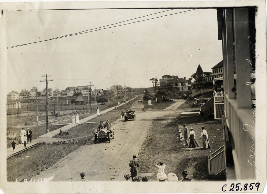 Automobiles traveling past houses, 1910 Munsey Historic Tour