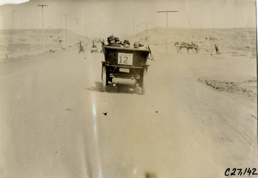 Motorists in automobile traveling on rural road, 1909 New York Economy Contest