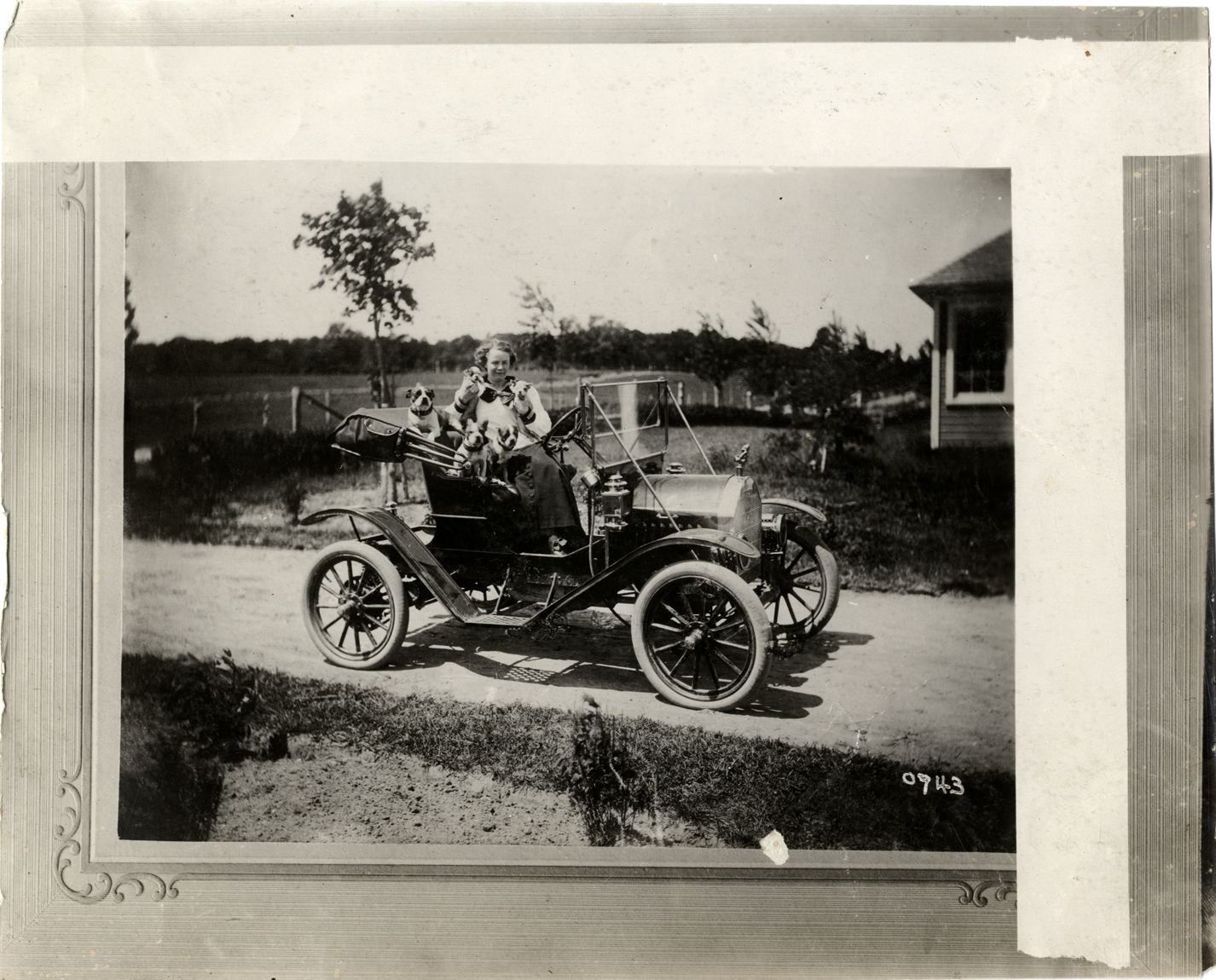 Woman with dogs posing in a Brush automobile