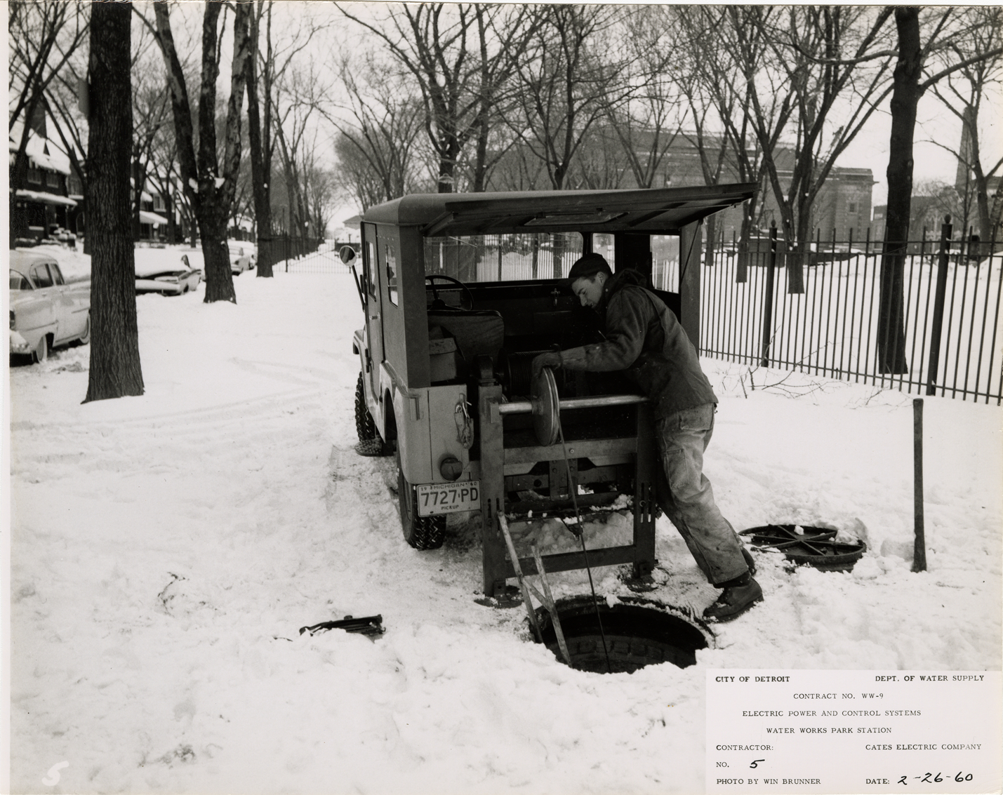 Worker pulling cable between manholes, Waterworks Park, Detroit water supply system
