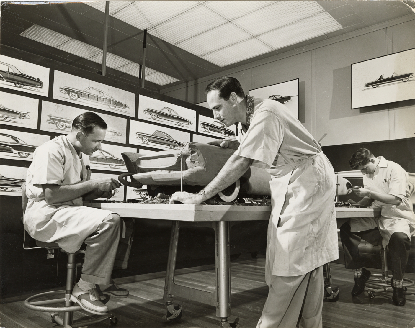 Clay modelers working on model of Ford automobile