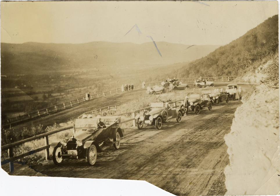 Motorists posing in 1917 Owen-Magnetic automobiles on roadside