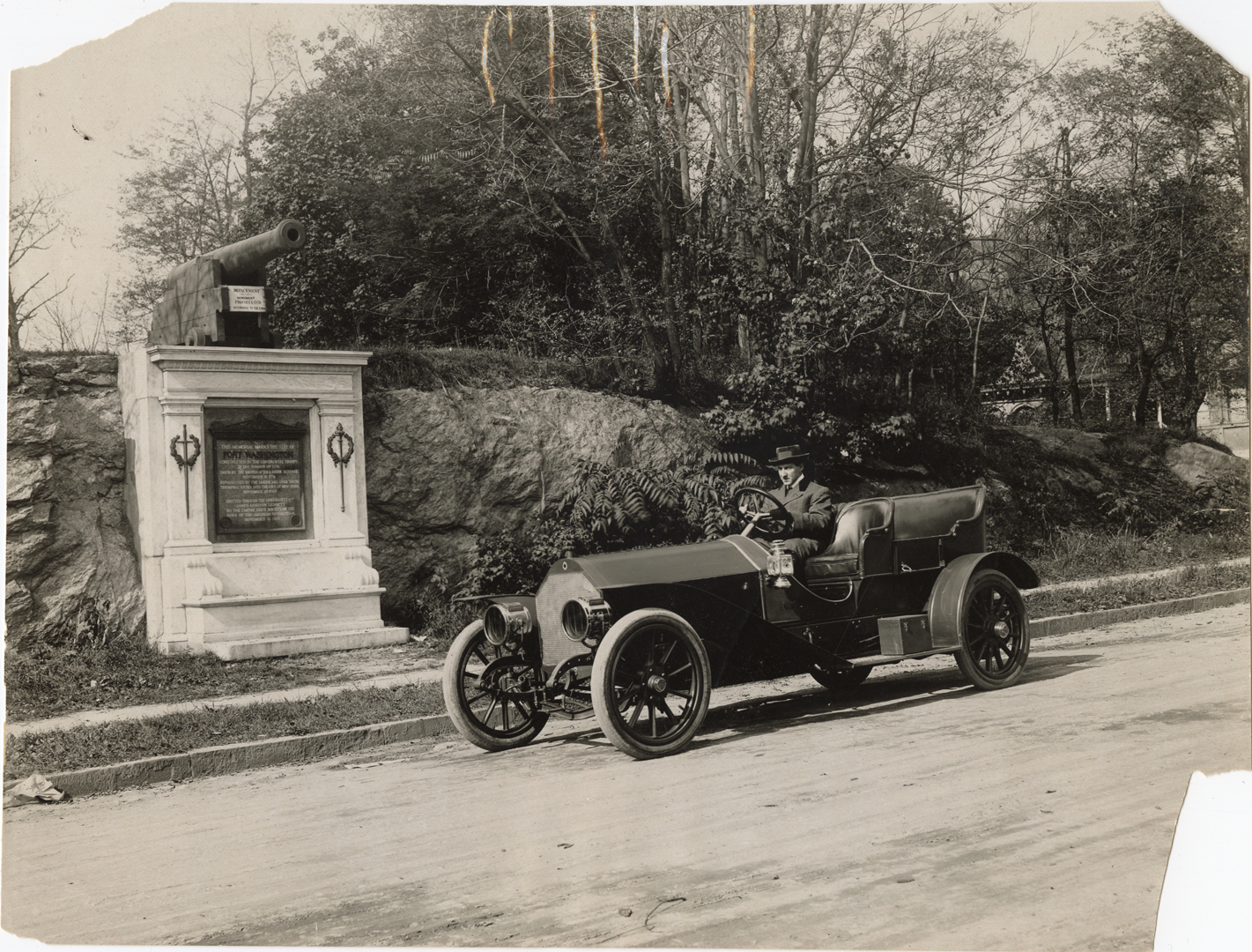 Driver in 1909 Palmer-Singer automobile in front of Fort Washington historical marker