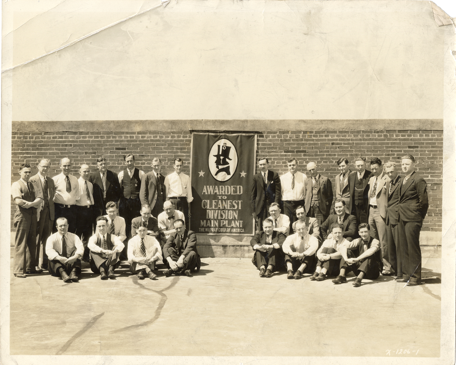 Employees posing with banner, Murray Corporation of America