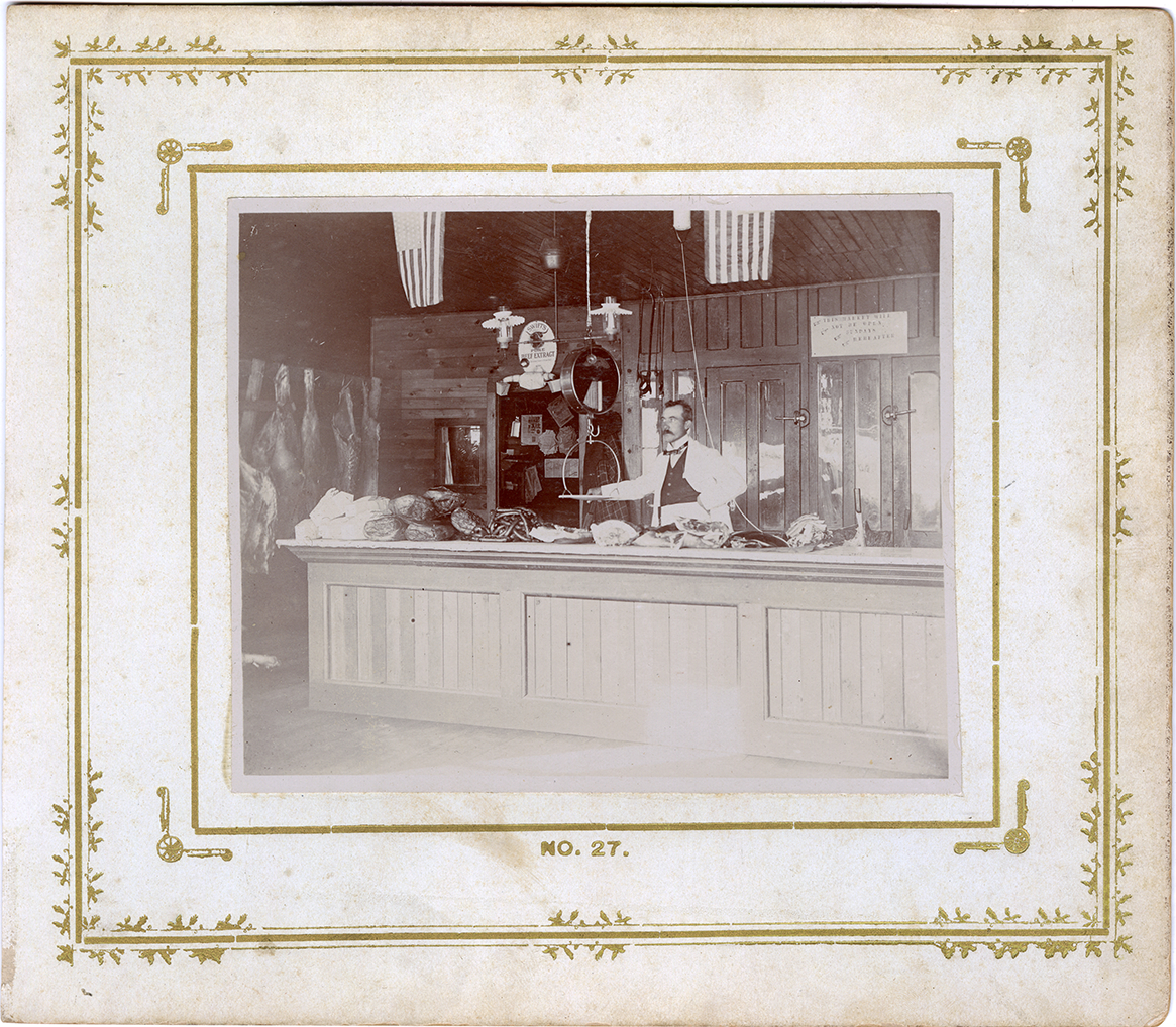 E. Albert Tunis behind counter at L.T. Barber meat market, Montrose, Michigan