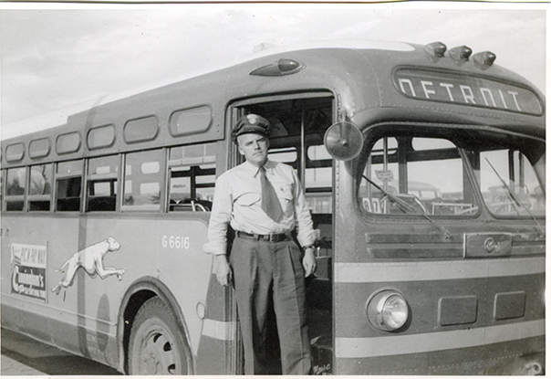 Warren Williams posing next to Greyhound bus, Hazel Park Raceway