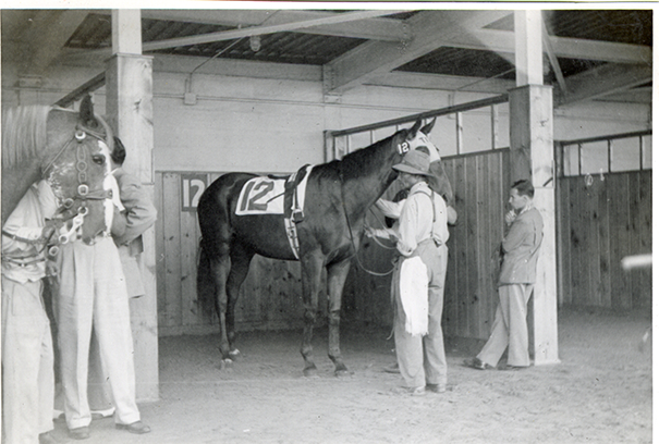 Groom with horse in stable, Michigan Racing Association racetrack