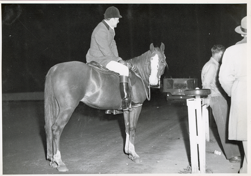 Steward James E. Stolte posing on horse "Riffles," Michigan Racing Association racetrack