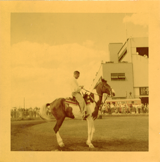Groom riding pinto horse, Hazel Park Raceway
