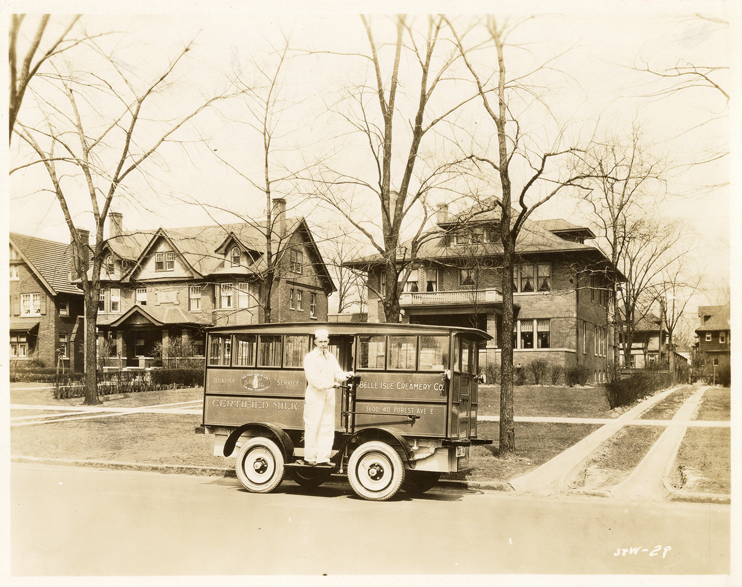 Dairyman posing with Belle Isle Creamery vehicle